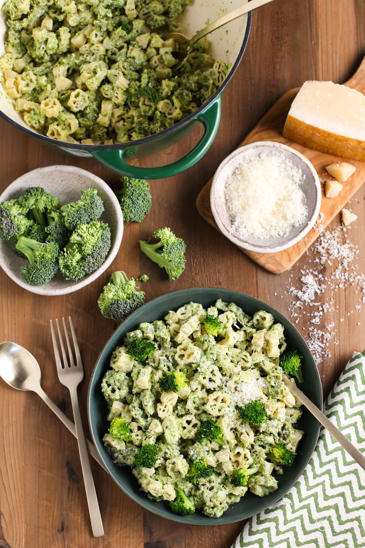 Small bowl of creamy broccoli pasta surrounded by ingredients
