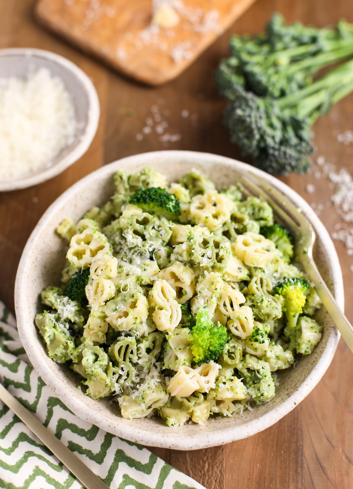 Small natural bowl of pasta showing dollar sign pasta shape with fresh broccolini in background