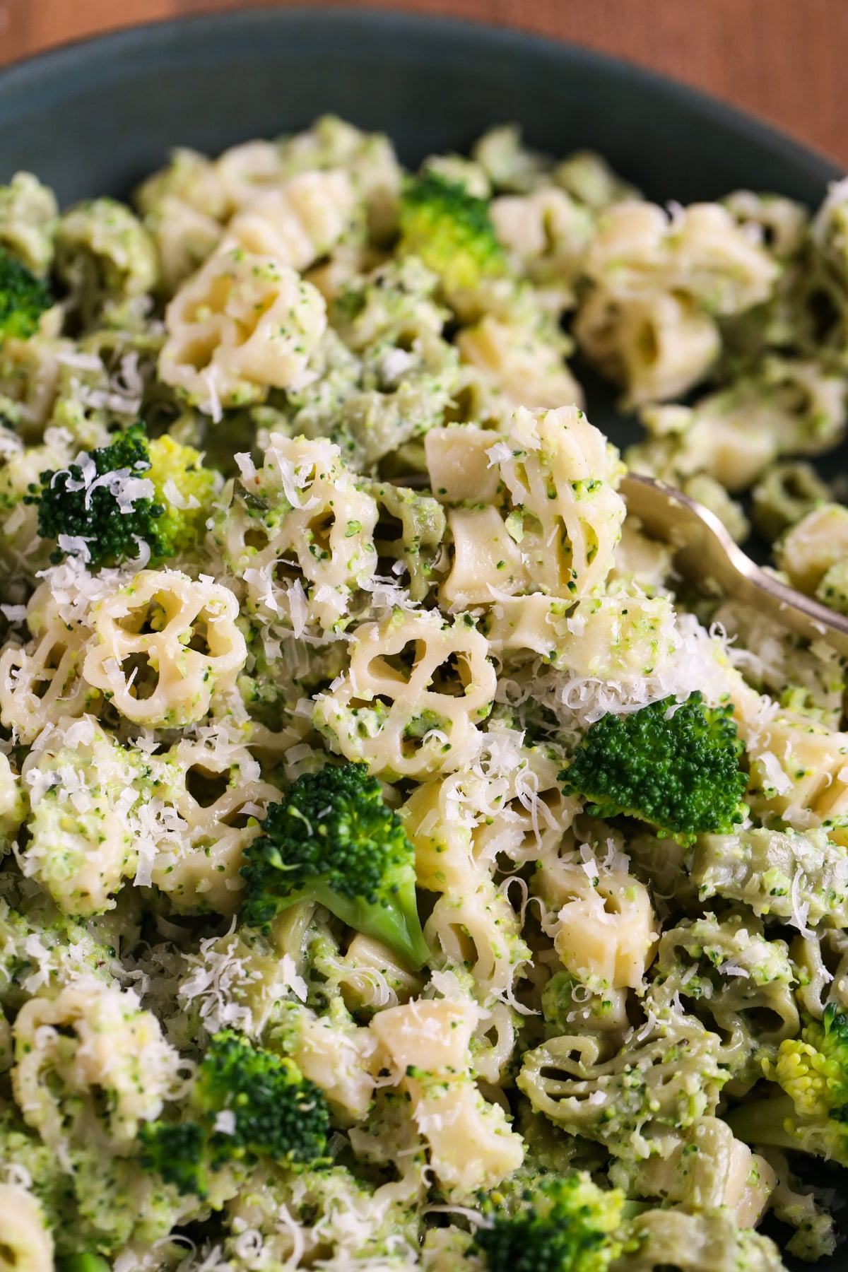 Very tight shot of finished pasta showing off shapes and fresh Parmesan and broccoli