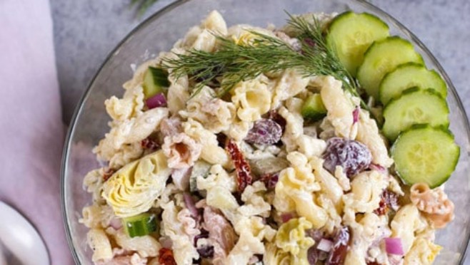 Tzatziki Pasta Salad | Cool and tangy Tzatziki Pasta Salad is the perfect side for a hot summer night! Artichokes, sun dried tomatoes, Kalamata olives, and crunchy cucumbers add just the right Greek flavors. Yum! Serve with grilled meats or chicken! Enjoy! | WorldofPastabilities.com