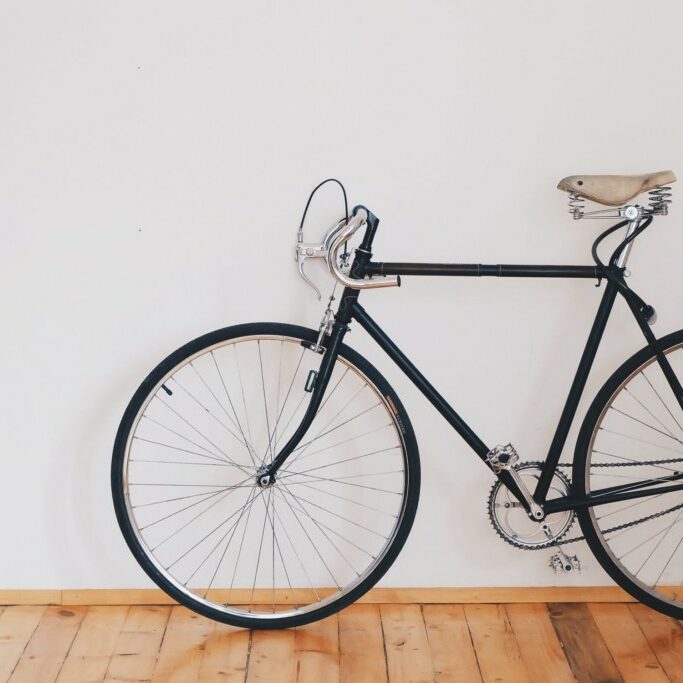 bicycle leaned up against white wall