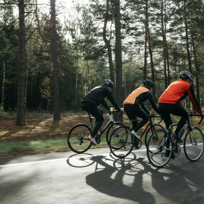 men cycling through forest