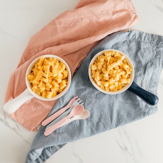 pink and blue bowls of mac and cheese