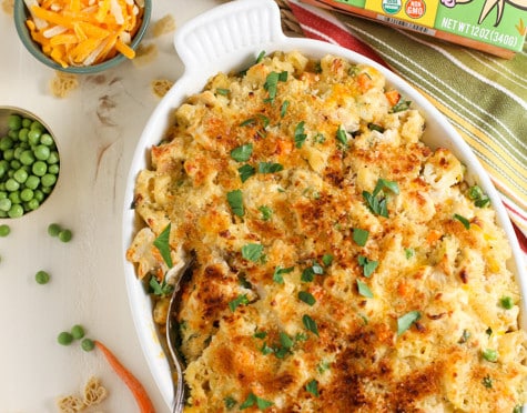 Chicken Noodle Casserole presented in a large ceramic dish with ingredients sprinkled around.