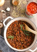 Pot of Lentil Bolognese with ingredients surrounding